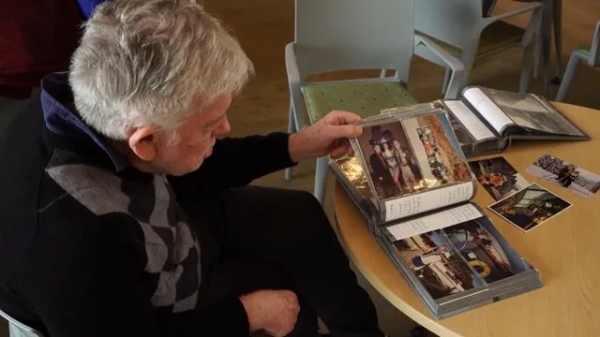 자신의 여행과 모험 사진이 가득한 추억의 앨범을 보고 있는 앨런 / globalnews.ca/news/9663849/dementia-village-canada