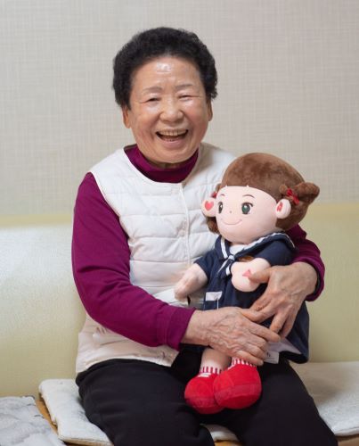 효돌이에게 예쁜 옷을 입히고 즐거워하는 할머니