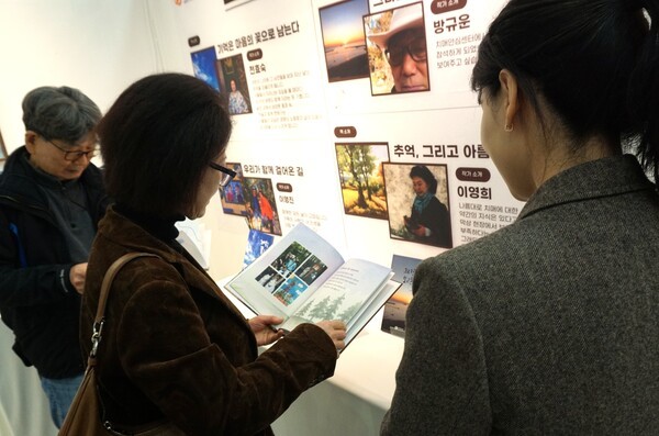 용산구치매안심센터 프로그램에 참여한 어르신이 직접 만든 그림책을 보고 있다. / 디멘시아뉴스