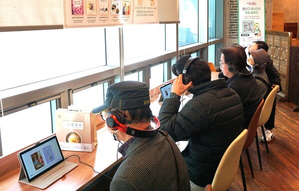 관람객들이 그림책 제작에 참여한 어르신들이 직접 녹음한 오디오북을 듣고 있다. / 디멘시아뉴스