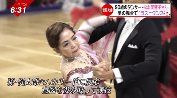 90세 댄서 마쓰나가 미치코 씨가 손자 겐타로의 리드를 받아 세계대회 플로어에서 연기하는 장면. 세대를 잇는 호흡과 노련한 표현력으로 감동을 일으켰다 / 유튜브 난카이방송 NEWS CH.4 보도 영상 캡처